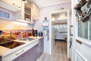 Una cocina moderna con estufa integrada, un lavamanos y armarios de madera.