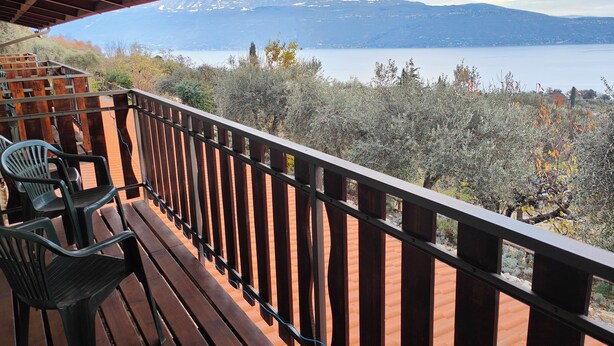 A wooden deck with a view of a lake and mountains. - Agriturismo Scuderia Castello (Toscolano Maderno)