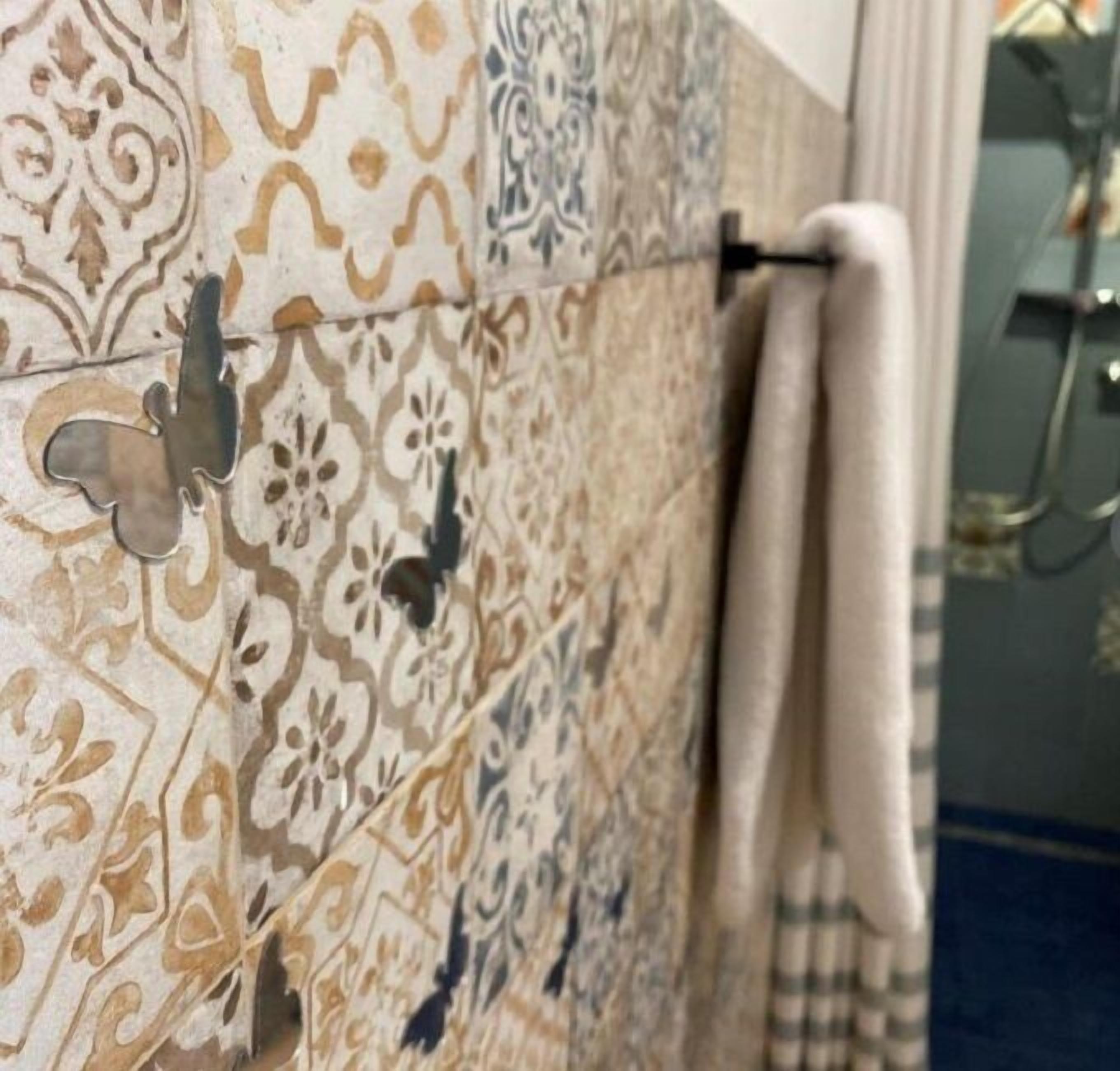 A bathroom with patterned tiles, a towel rack, and a shower area.