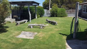 A backyard with a wooden bench, a pergola, and a hose. - Hillocks Homestead Overlooking the Bush (Marion Bay)