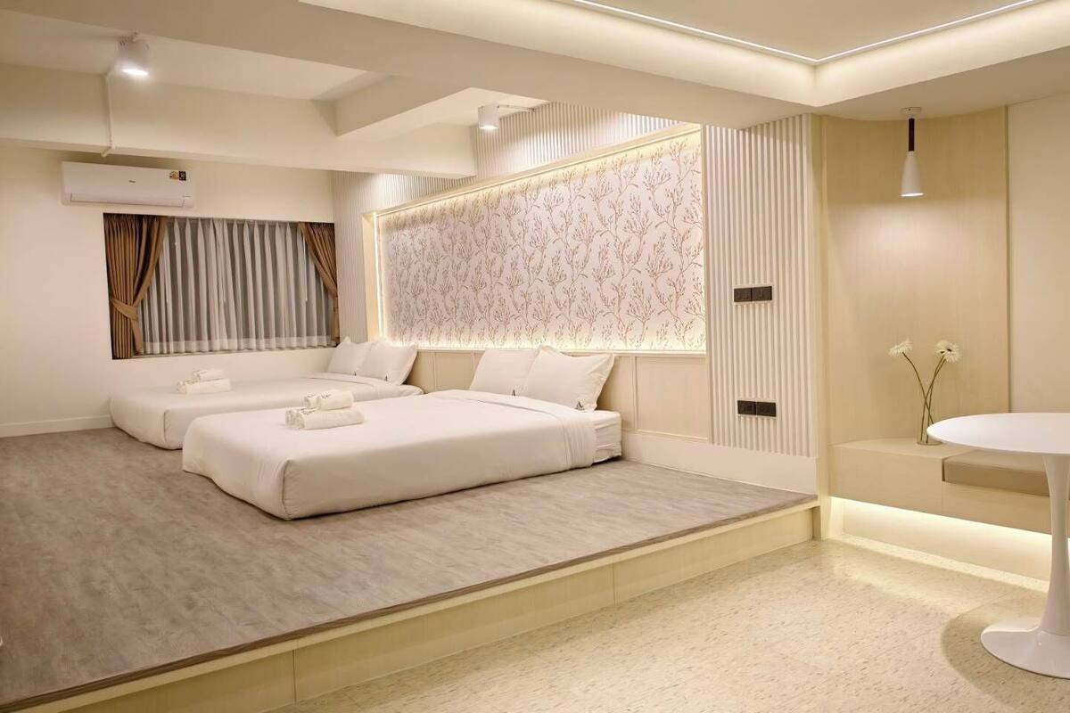A modern bedroom with a large bed, a bedside table, and a small round table.