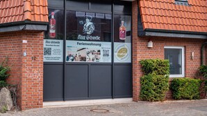 A brick building with a large window displaying a QR code, a sign for 'Alter Schwede,' and a logo for 'Blumenhals Distillery.' - Apartment 'Die Alter Schwede 2' with Shared Terrace and Wi-Fi (Vechta)