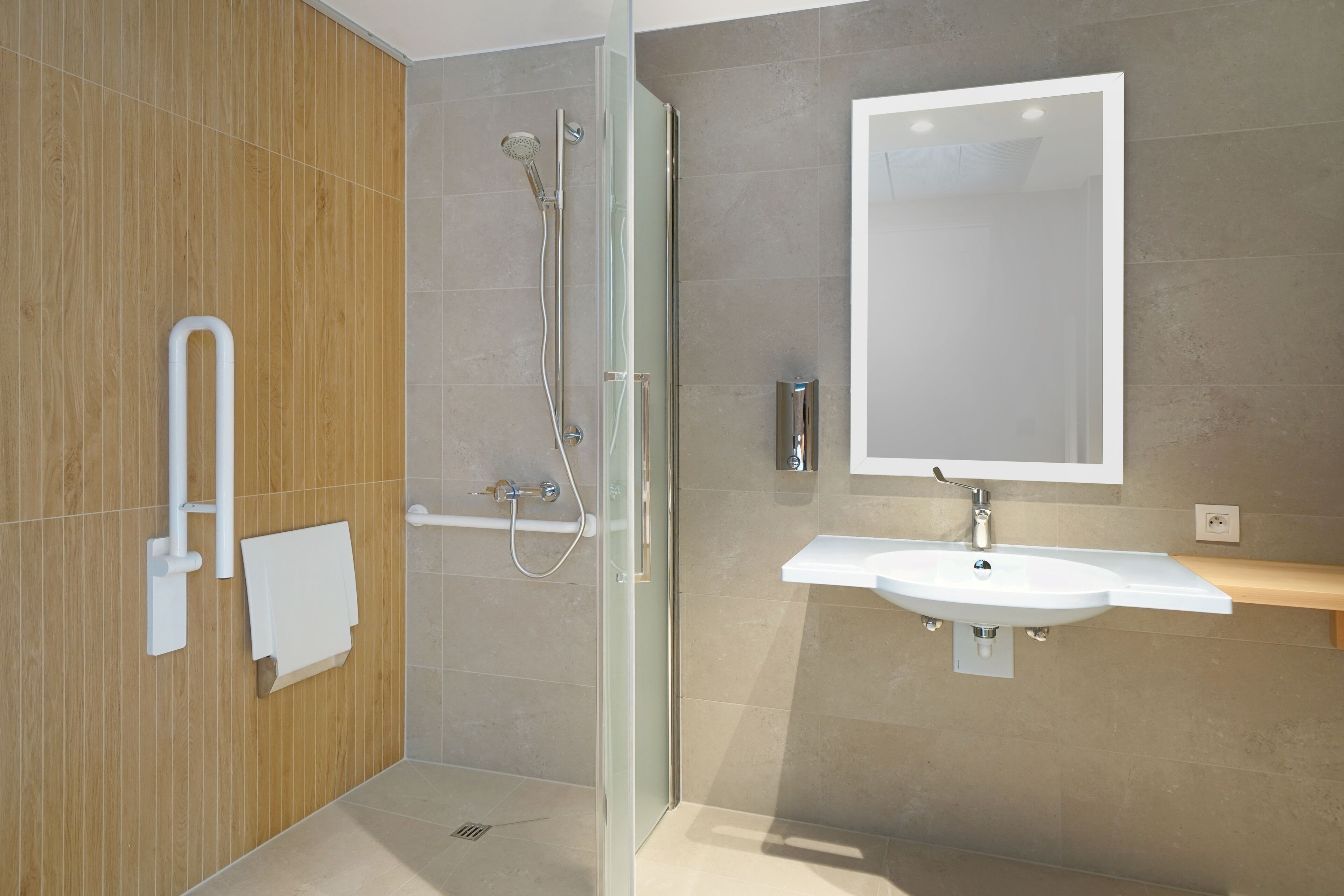 A modern bathroom with a glass shower enclosure, a white sink, and a large mirror.