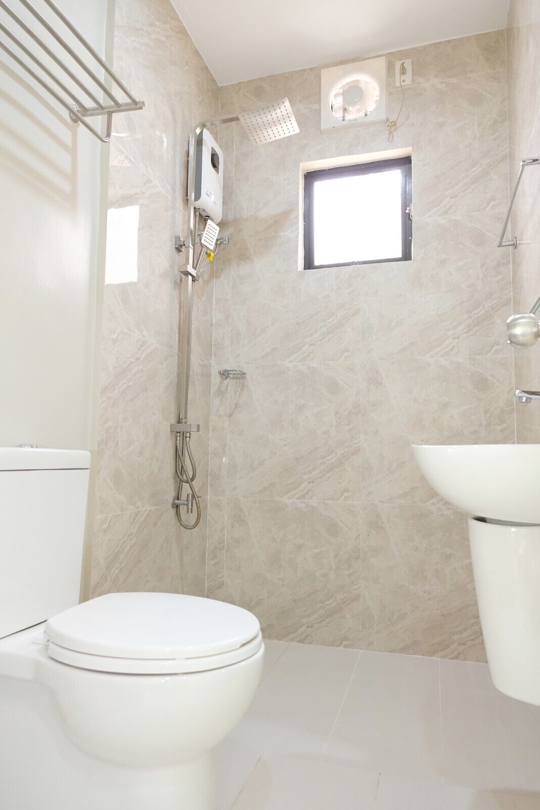A modern bathroom with a toilet, a shower, and a sink.
