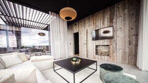 A modern living room with a black coffee table, white sofa, and green ottoman. - Modern Maison Near Somme-leuze (Somme-Leuze)