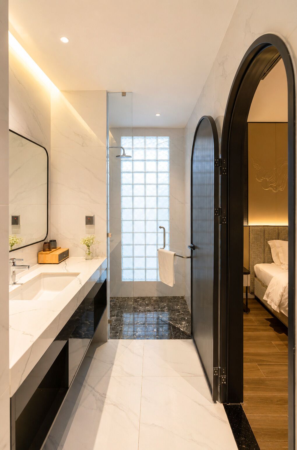 A modern bathroom with a large mirror, a shower, and a vanity with a sink.