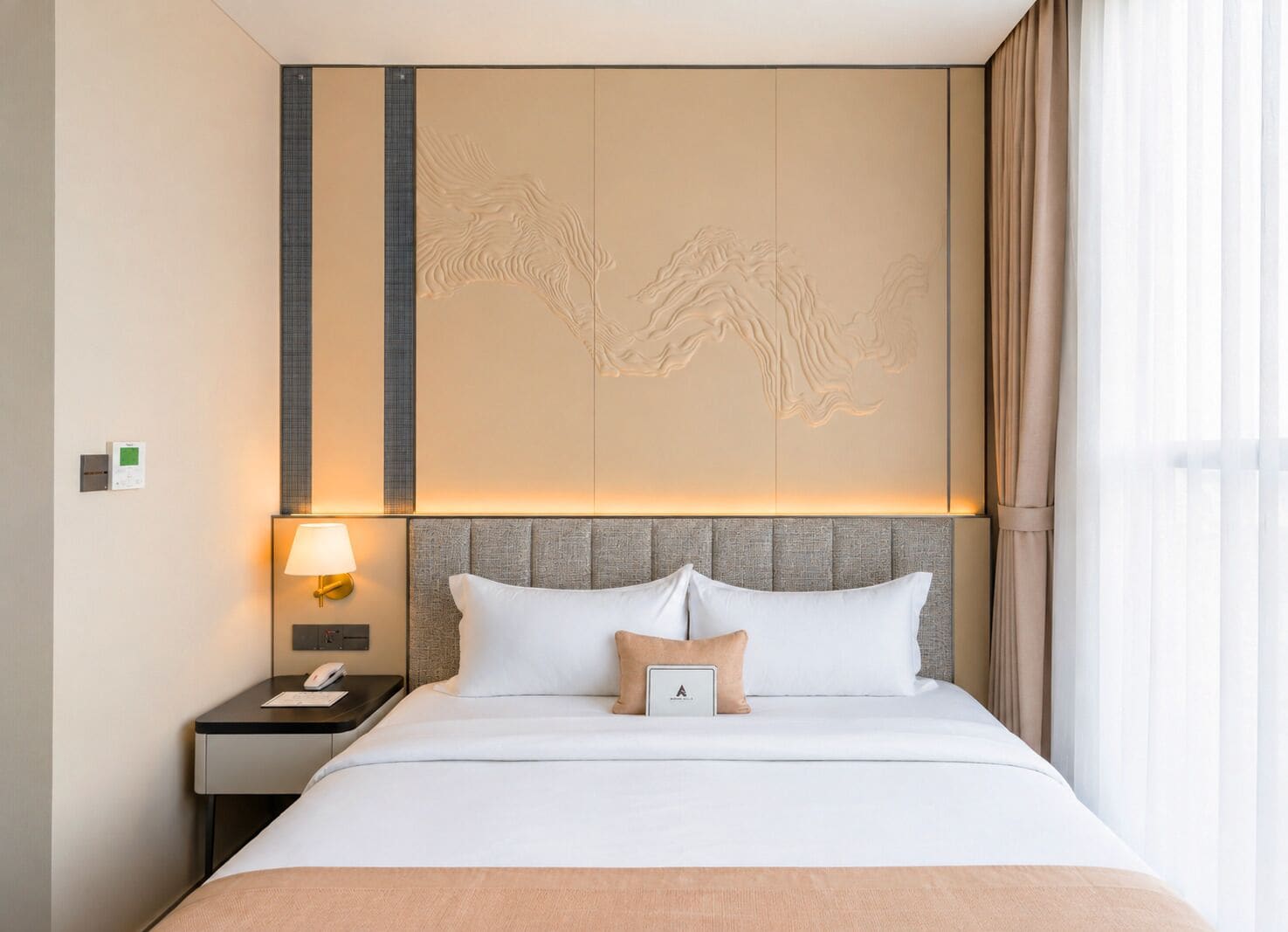 A hotel room with a bed, a nightstand, a lamp, and a wall with a decorative panel.
