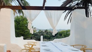 Mesa para dos con manteles blancos y vista a un paisaje montañoso.
