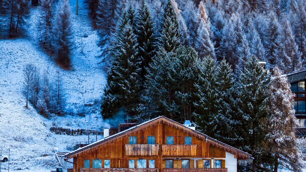 A wooden chalet with a balcony, surrounded by snow-covered trees and mountains in the background. - Casa Guargne' (Cortina d'Ampezzo)