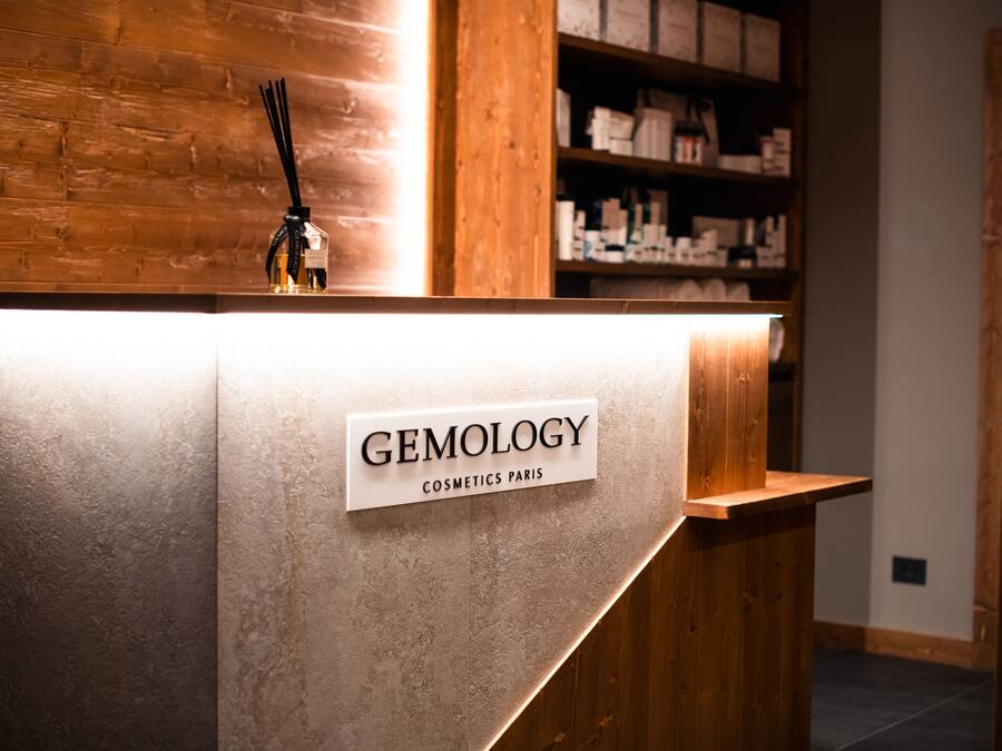 A reception desk with a sign reading "GEMOLOGY COSMETICS PARIS".