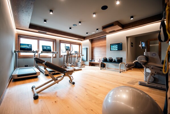 A gym with treadmills, exercise bikes, and free weights.