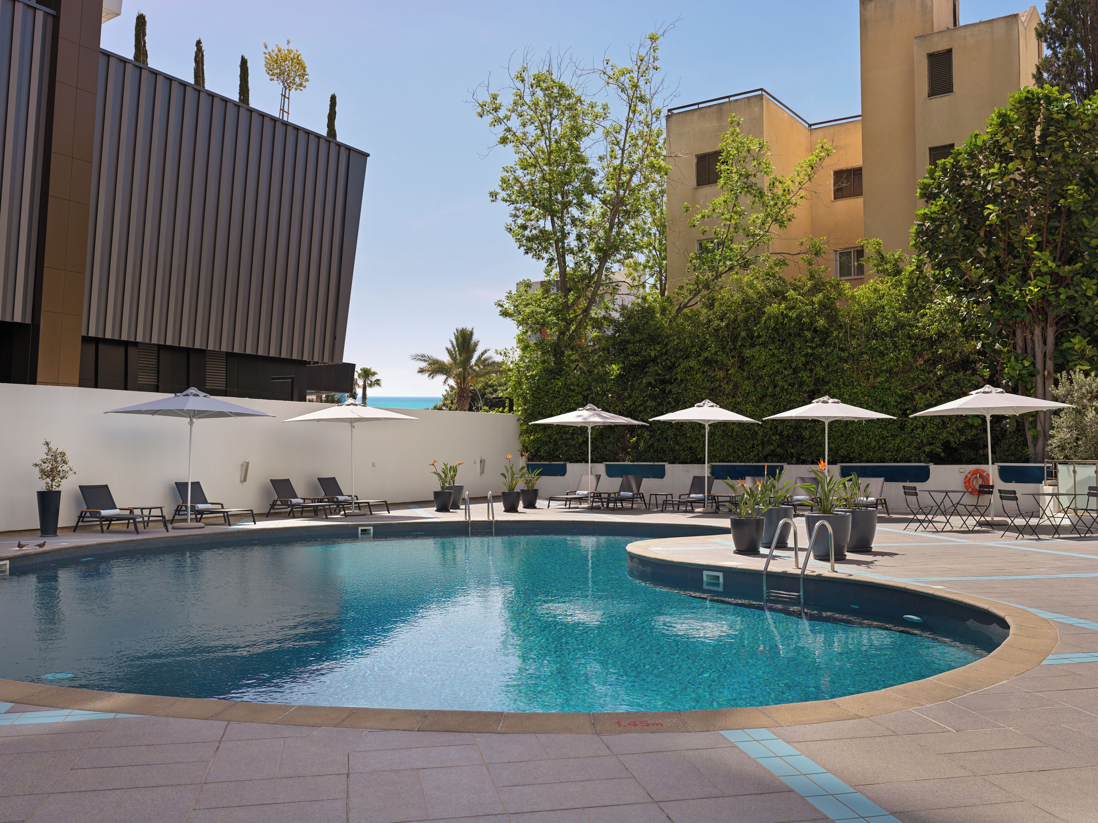 Una piscina al aire libre de temporada, sombrillas