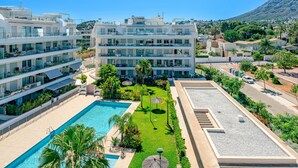 A modern hotel with multiple balconies, a swimming pool, and a landscaped garden. - Marina Real I by Interhome (Dénia)