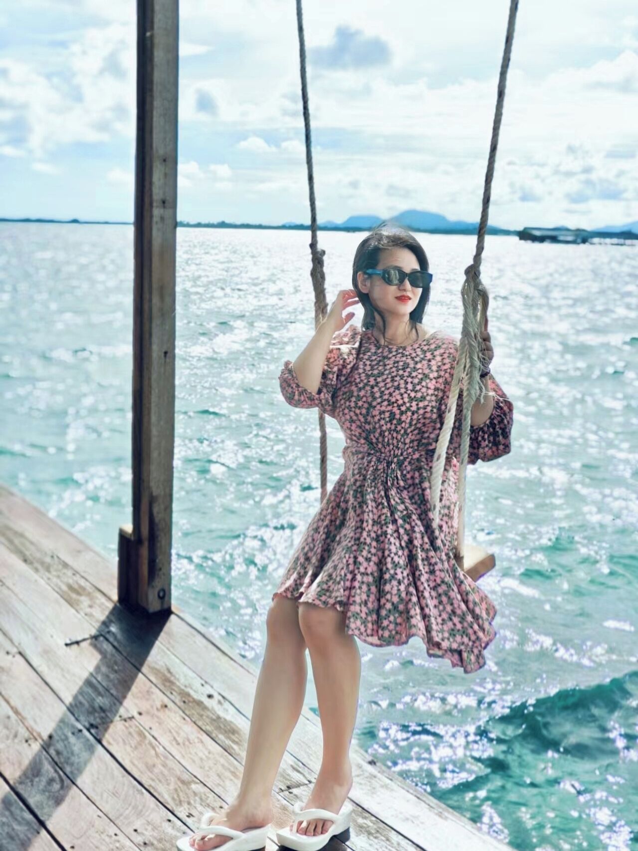 A person on a swing over a body of water.