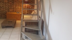 Een moderne trap met metalen leuningen en een bakstenen muur op de achtergrond.