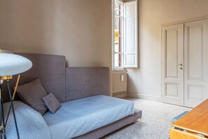 A room with a bed, a lamp, a window, and a wardrobe.