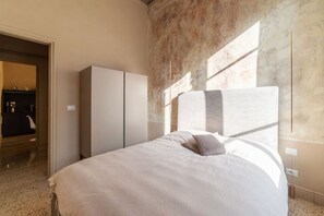 Un dormitorio con cama, armario y vistas al exterior.