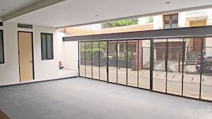 Une pièce spacieuse avec un grand espace ouvert, une porte et une fenêtre.