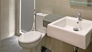 Une salle de bain avec des toilettes, une douche et un lavabo.