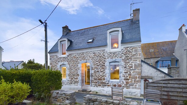 A stone house with a sloped roof, multiple windows, and a small porch area. - House for 5 to 50m from the seafront (Penmarch)