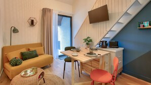 Una sala de estar moderna con un sofá, una mesa de comedor y una escalera.