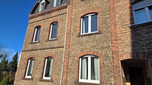 A multi-story brick building with arched windows and a visible door.
