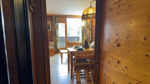 Ein Holzinterieur mit Esstisch, Stühlen und einem Fenster mit Vorhängen.
