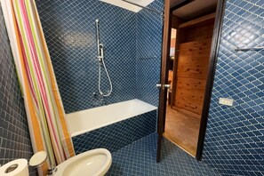 Een haardroger, een bidet, handdoeken, toiletpapier