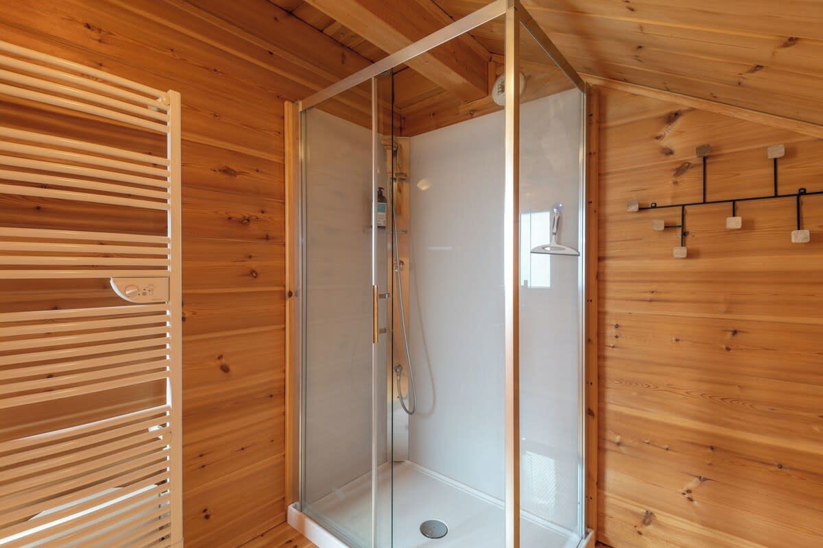 A wooden interior with a glass-enclosed shower area.