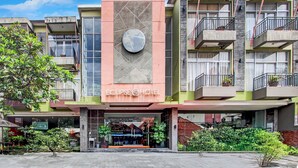 A hotel with a prominent sign, multiple balconies, and a well-maintained exterior.