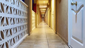 A hotel corridor with a tiled floor, white doors, and a decorative white partition on the left. - Charming Studio with Terrace and Sea Views, in Costa del Silencio (Costa del Silencio)