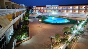 A hotel courtyard with a swimming pool, multiple balconies, and outdoor seating areas. - Charming Studio with Terrace and Sea Views, in Costa del Silencio (Costa del Silencio)