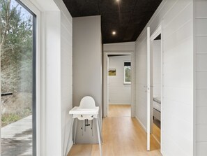 Stylish hallway leads to a cozy bedroom with a bed and window.