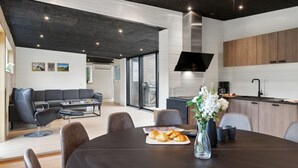 Un espacio habitable moderno con comedor, cocina y un ventanal grande.