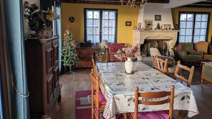 Un comedor acogedor con una mesa de madera, sillas y un árbol de Navidad.