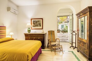Un dormitorio con cama, cómoda, silla y vistas al exterior.