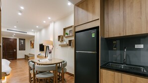 A modern kitchen with wooden cabinets, a black refrigerator, and a built-in sink.