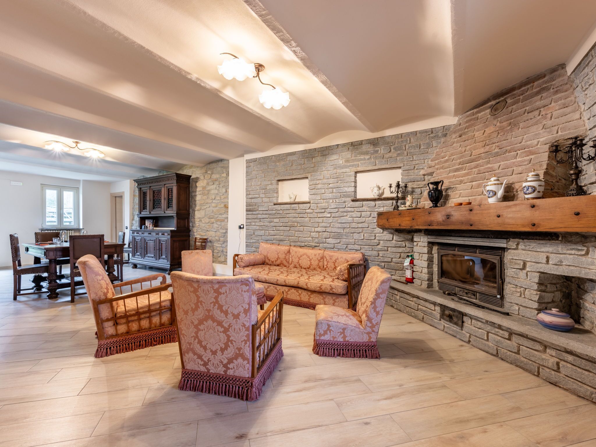 A cozy living room with a stone fireplace, a wooden coffee table, and patterned sofas.