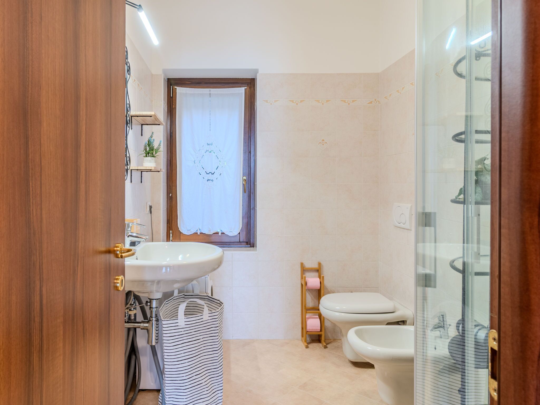 A bathroom with a sink, toilet, and shower area.