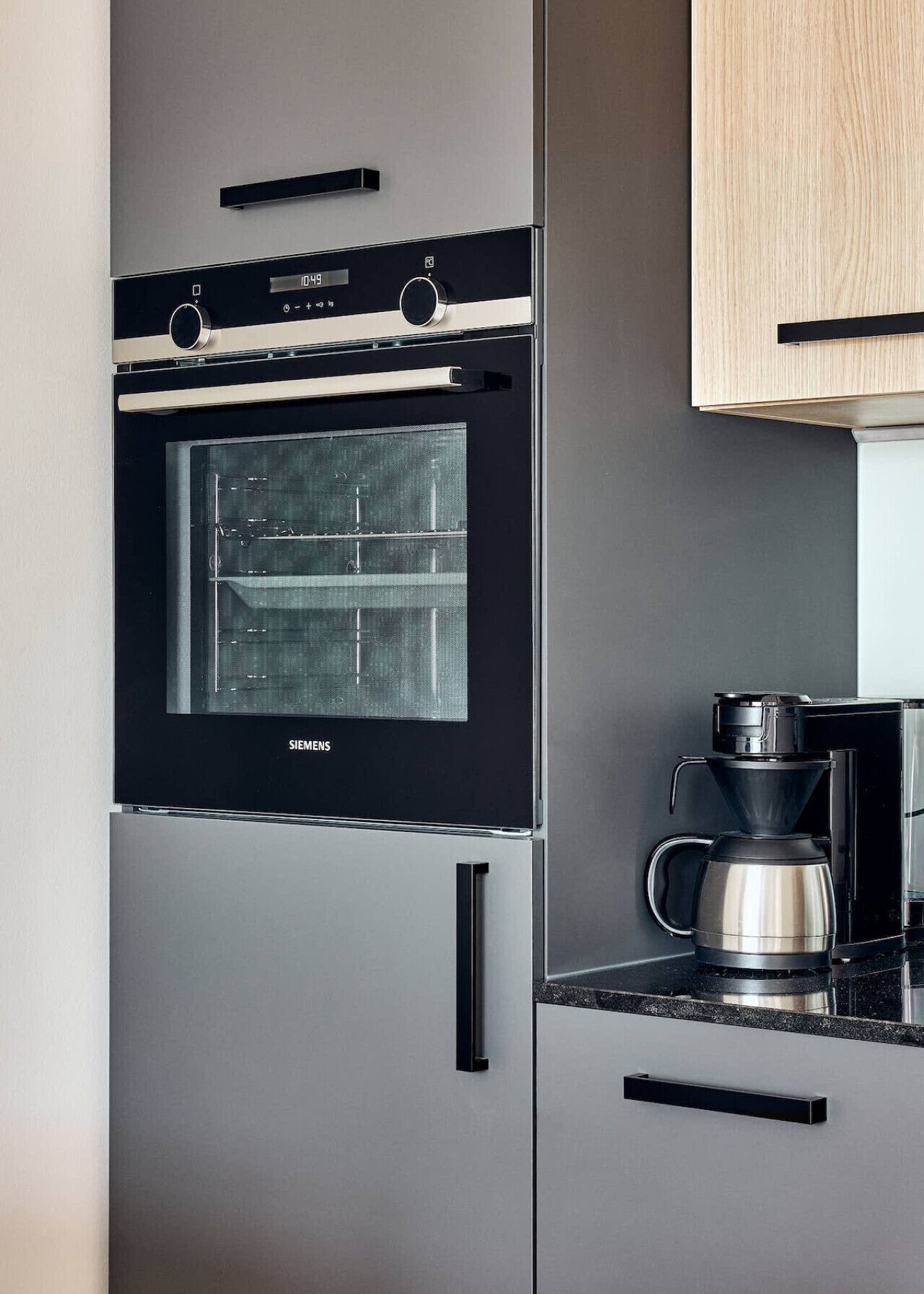 Una cocina con horno empotrado y cafetera.