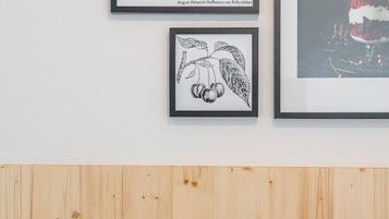Una habitación con cabecera de madera, almohada blanca y una cita enmarcada en la pared.