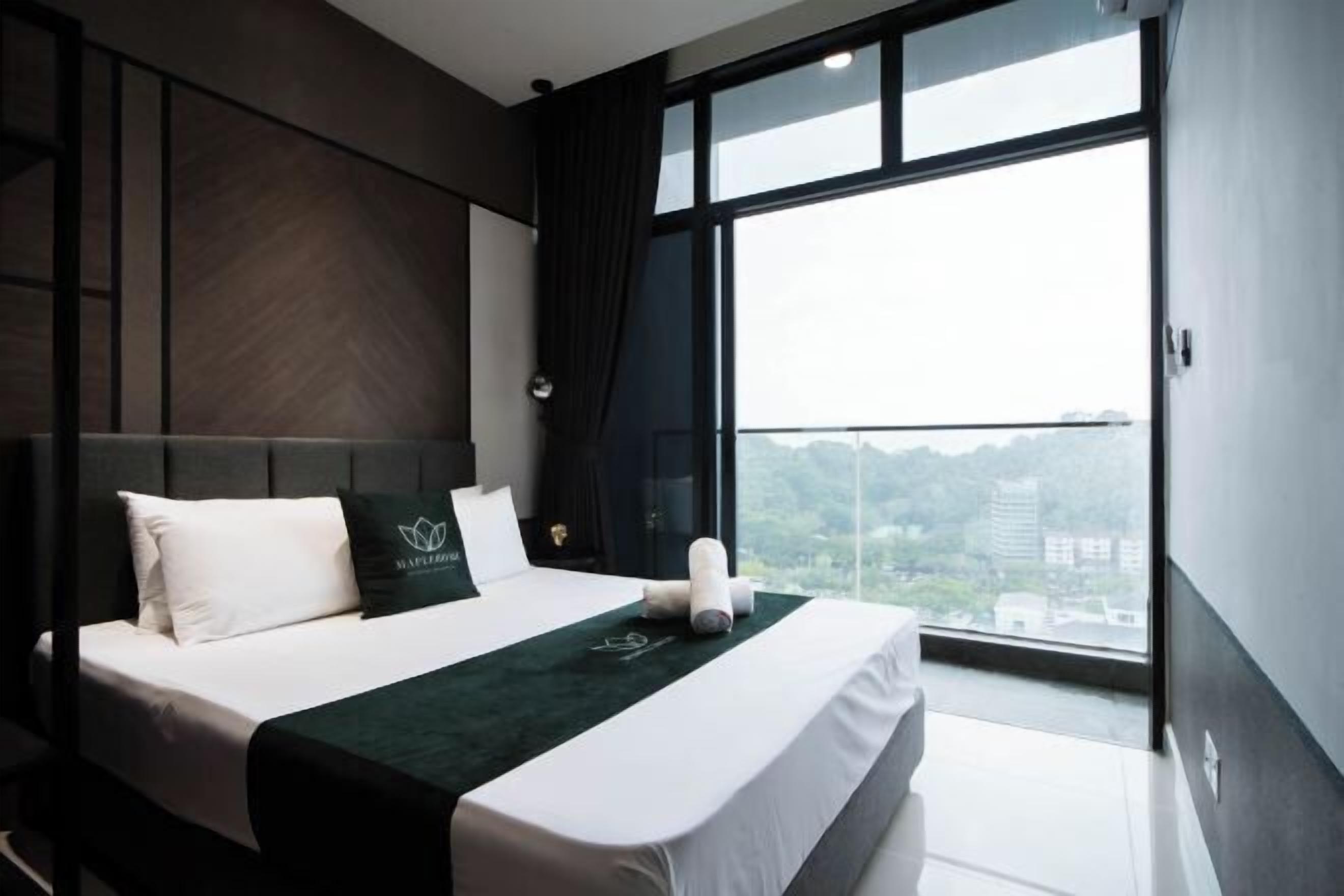 A modern hotel room with a large bed, a view of the city, and a balcony.