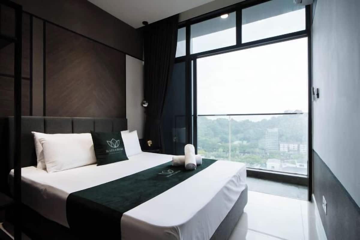 A modern hotel room with a large bed, a view of the city, and a balcony.