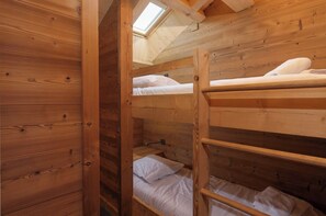 A bunk bed room with wooden walls and a skylight. - L'Aiglon - 10 pers - Jacuzzi + Sauna (Gérardmer)