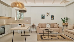 A modern kitchen with a dining table, a sofa, and a coffee table in a spacious living area. - Villa Danae Periyali (Zakynthos)