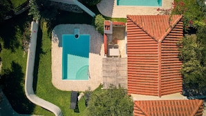 An aerial view of a property with two swimming pools, a patio area, and a red-tiled roof. - Villa Lito Periyali (Zakynthos)