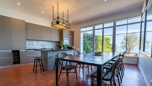Una cocina amplia con una isla grande, electrodomésticos modernos y vistas al exterior.