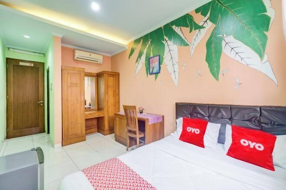 Une chambre d’hôtel avec un lit, un bureau et une chaise.