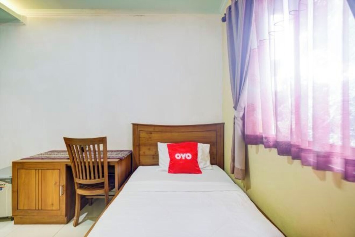 Une chambre à coucher avec un lit en bois, un bureau et une chaise.