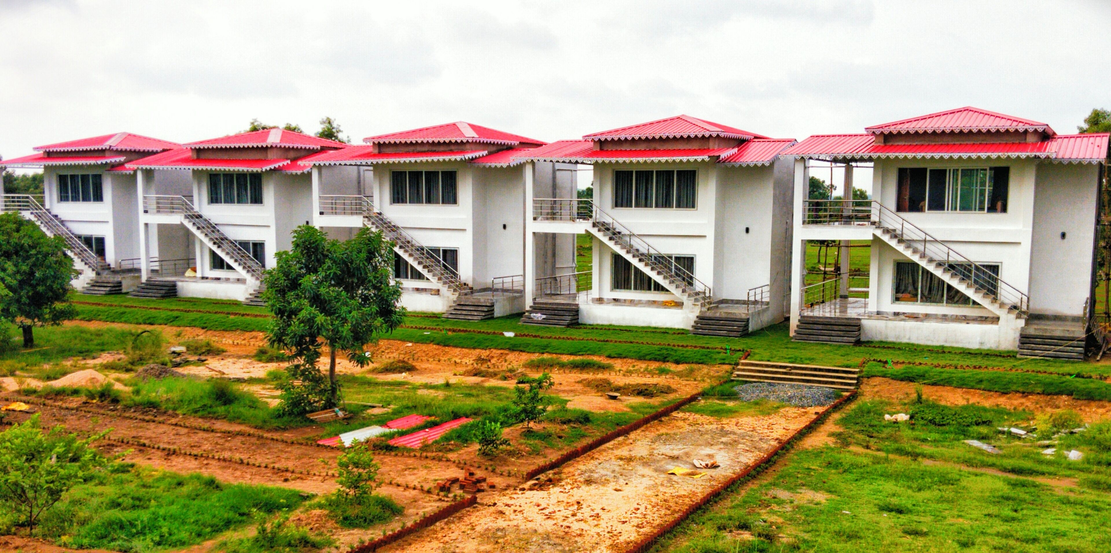 A row of white buildings with red roofs and multiple staircases leading to the entrance.